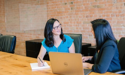 Two women at a desk.