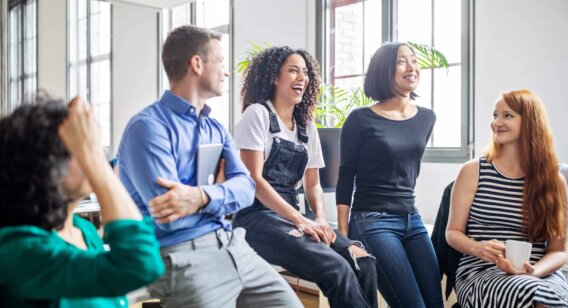 A group of people engaging in a discussion at an office.