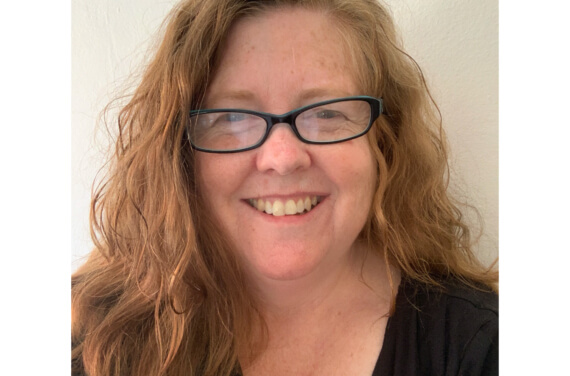 Woman wearing glasses and smiling at the camera