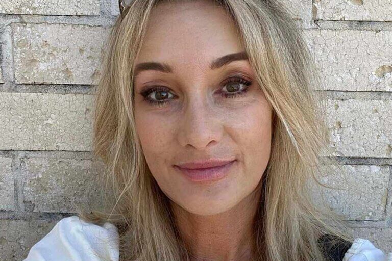 A headshot of a woman in front of a brick wall.