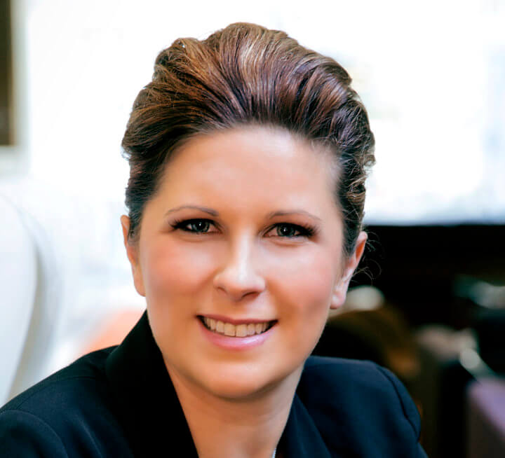 Woman in black jacket smiling facing front