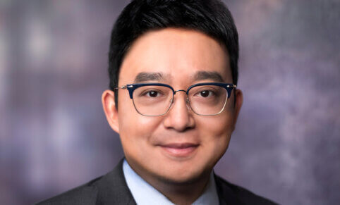 Portrait image of man in suit wearing glasses. Sean Dong