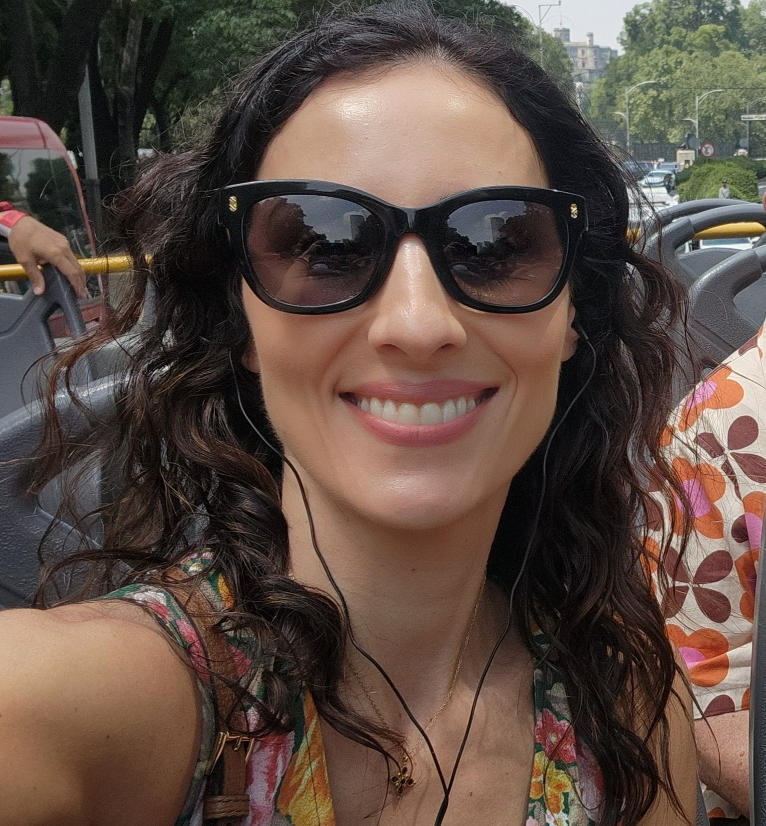 woman in sunglasses with headphone smiles in selfie