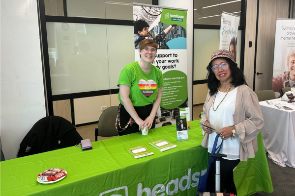 woman in headspace branding at expo stall with a woman wearing a white shirt and bucket hat