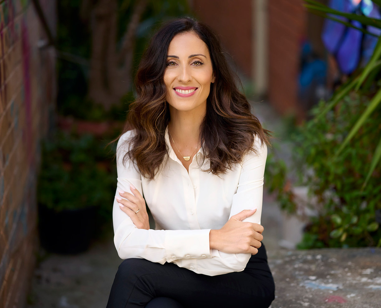 Photo of GDLP course leader Desi Vlahos sitting with her legs and arms crossed