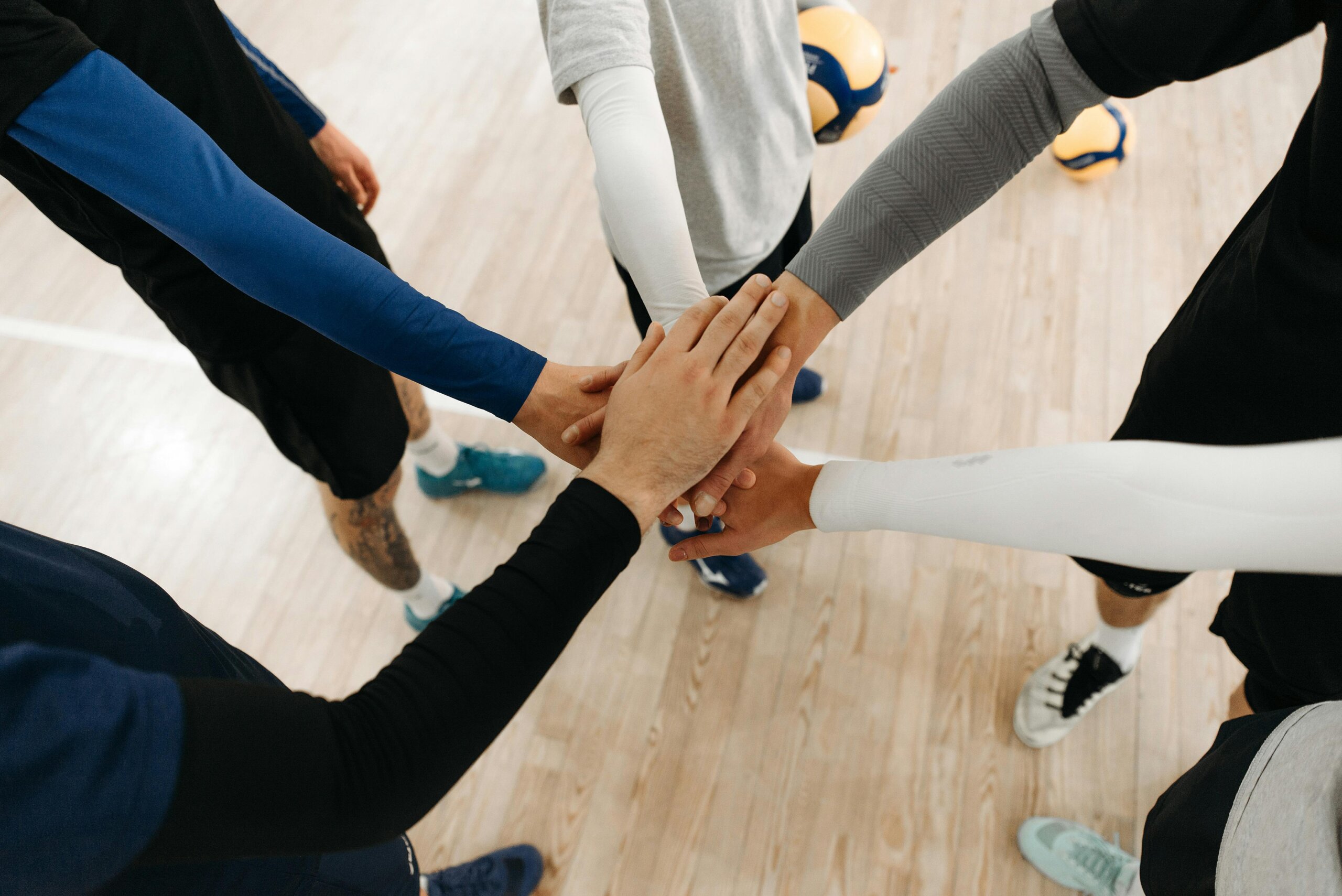 A team playing a sport game doing the hands-in cheer.
